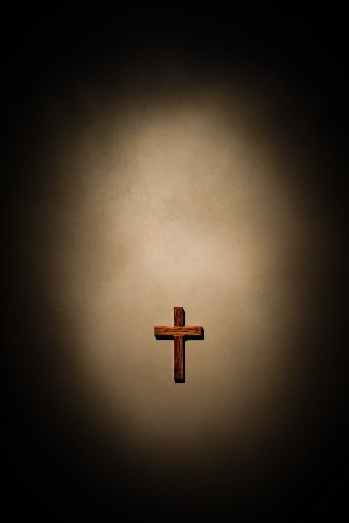 Holz Kreuz mit Licht und dunklem Hintergrund 