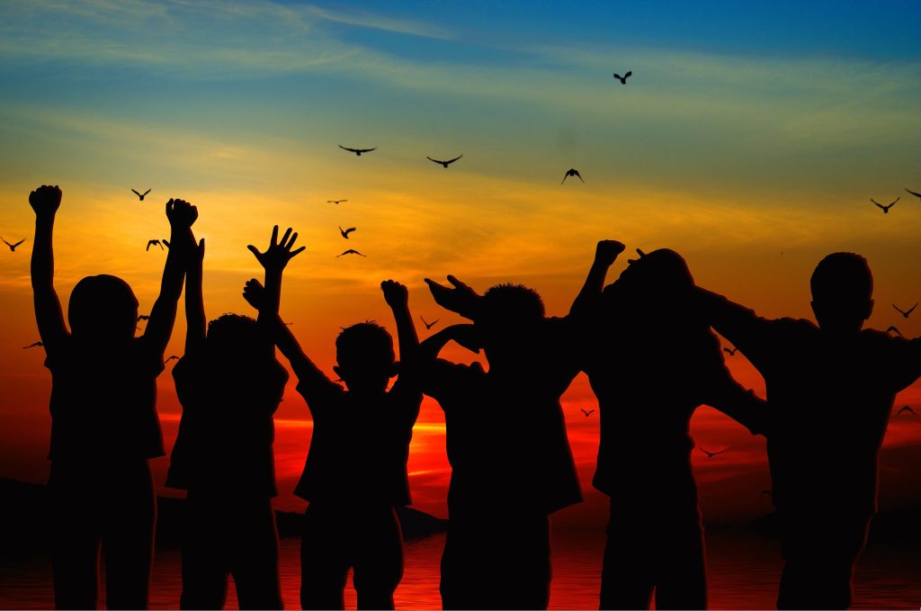 fröhliche Kinder mit Sonnenuntergang 
